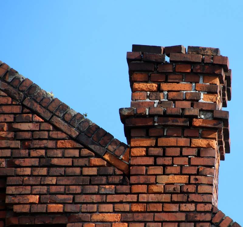 Damaged chimney on an Pompano Beach home showing cracks and missing mortar